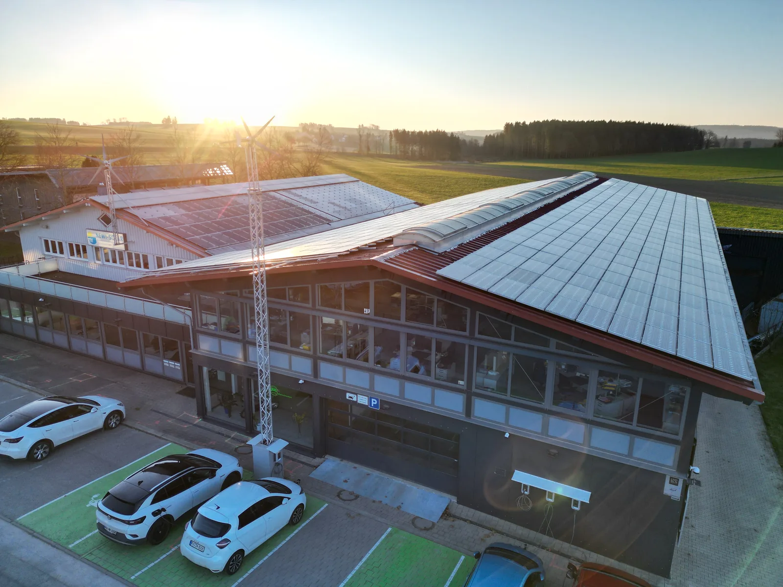 Aerial view of the reference site: commercial building with rooftop PV system and DC charging infrastructure